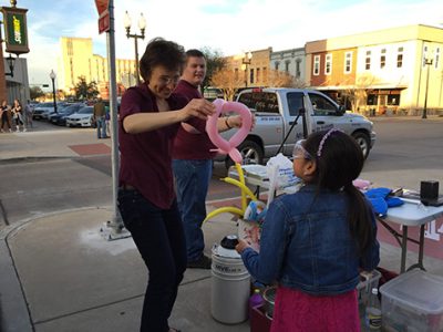 Dr. Tatiana making a balloon animal for a child.