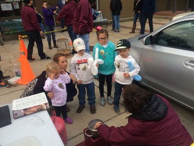 Children getting balloon animals that expand.