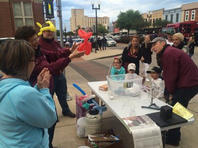 People grabbing balloon animals at First Friday.