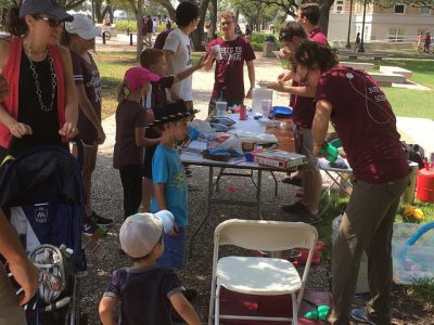 Students helping children with demos.