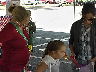 A girl blowing bubbles that float.