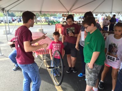 A student demonstrating with a bike wheel.