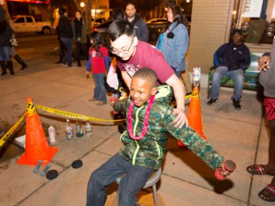 A little boy spins in a chair using angular momentum.