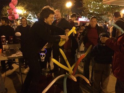 Dr. Tatiana making balloon animals for children at First Friday.